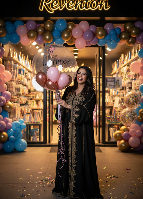 A clear, transparent birthday bubble balloon , tied with a colorful ribbon.